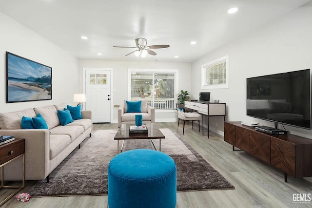 living room featuring light hardwood / wood-style floors and ceiling fan