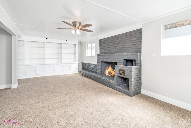 unfurnished living room with ceiling fan, built in features, carpet floors, and ornamental molding