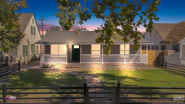 view of front facade featuring covered porch and a yard