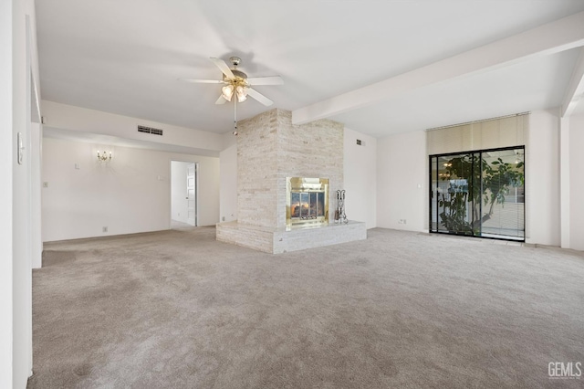 unfurnished living room with beam ceiling, ceiling fan, light colored carpet, and a brick fireplace