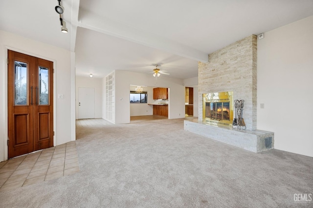 unfurnished living room featuring light carpet, a fireplace, ceiling fan, and beamed ceiling