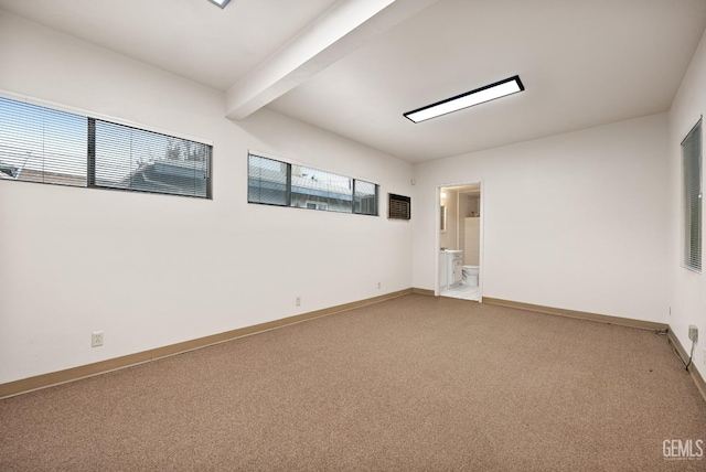 spare room featuring beam ceiling and plenty of natural light