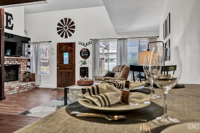 2316 Gosford Rd Unit R, Bakersfield, CA 93309 - living area featuring a fireplace, plenty of natural light, dark wood finished floors, and vaulted ceiling