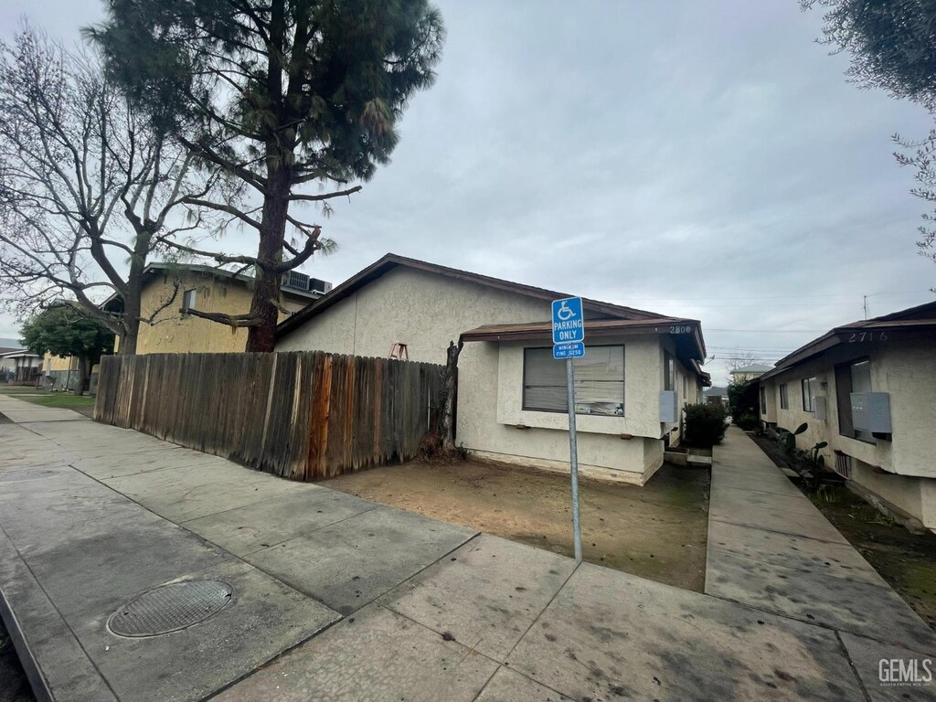view of side of property featuring fence and stucco siding