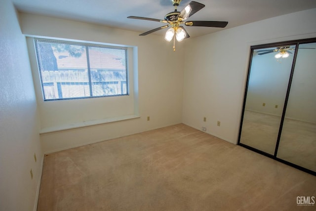 unfurnished bedroom featuring a closet, light carpet, and ceiling fan