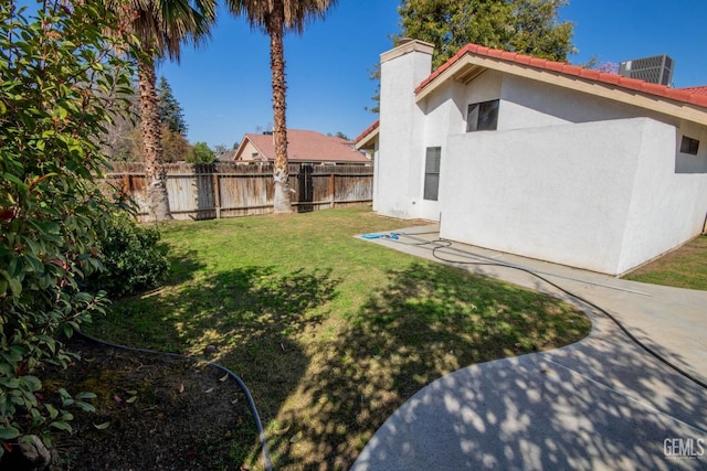 view of yard featuring central AC and fence