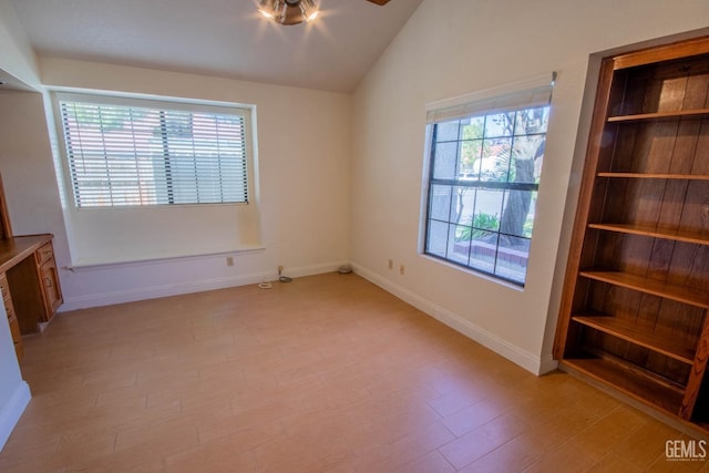 unfurnished bedroom featuring lofted ceiling, baseboards, and light wood-type flooring