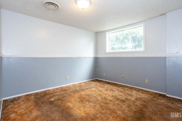 carpeted empty room featuring a textured ceiling