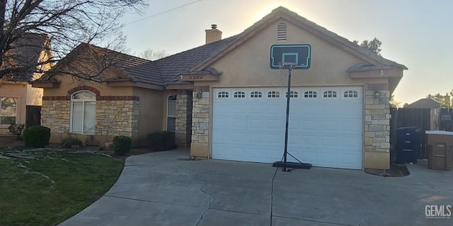 view of front of home featuring concrete driveway, an attached garage, and stucco siding