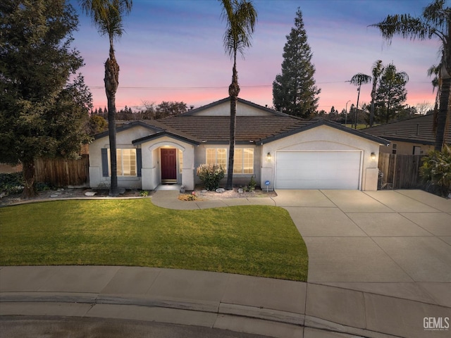 single story home featuring a yard and a garage