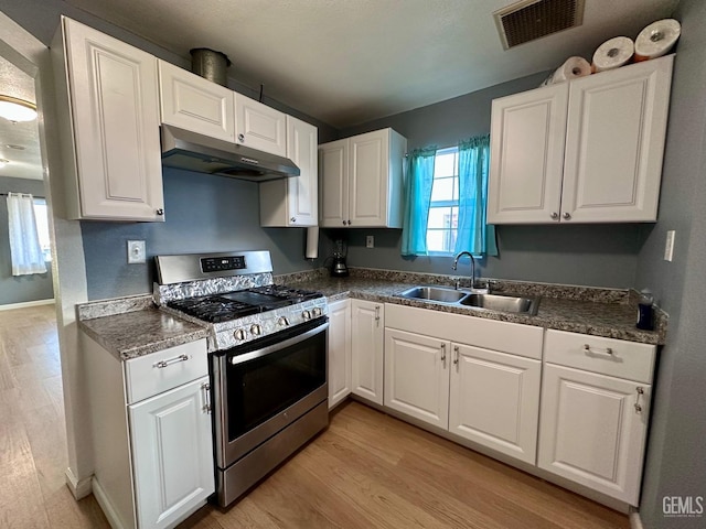 kitchen featuring white cabinetry, sink, gas stove, and light hardwood / wood-style flooring