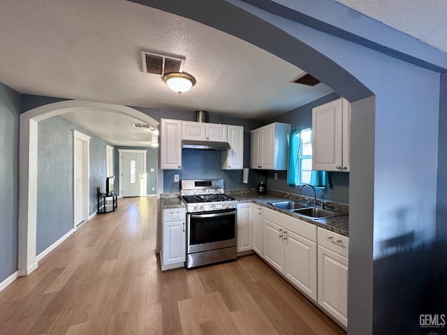 kitchen featuring white cabinetry, stainless steel range with gas cooktop, sink, and light hardwood / wood-style flooring