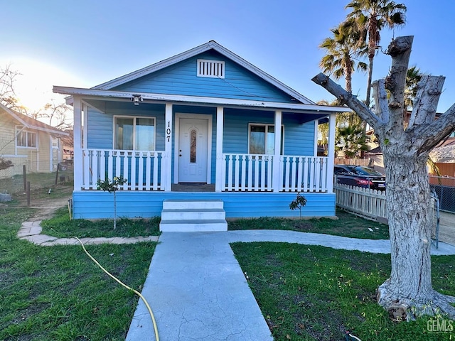 bungalow-style house with covered porch and a front lawn