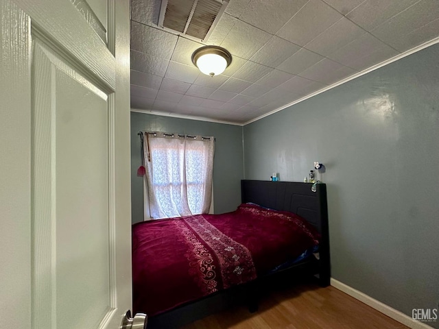 bedroom featuring hardwood / wood-style floors and ornamental molding