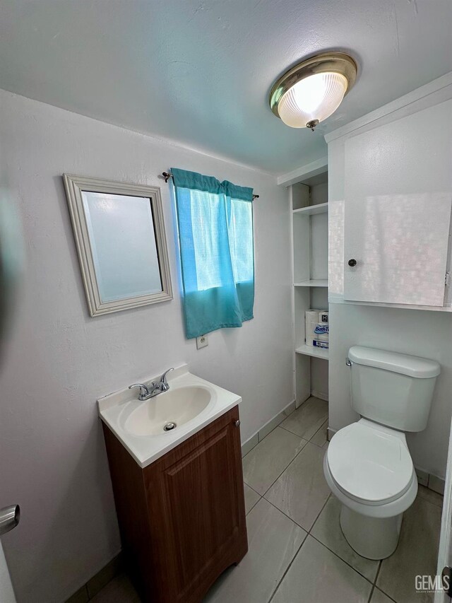 bathroom featuring vanity, toilet, and tile patterned flooring