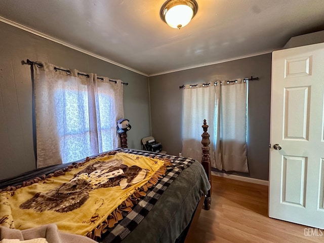 bedroom with crown molding and hardwood / wood-style floors