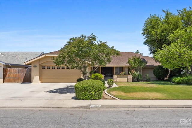 9408 Wandering Oak Dr, Bakersfield, CA 93311 - view of property hidden behind natural elements featuring a garage, driveway, and stucco siding