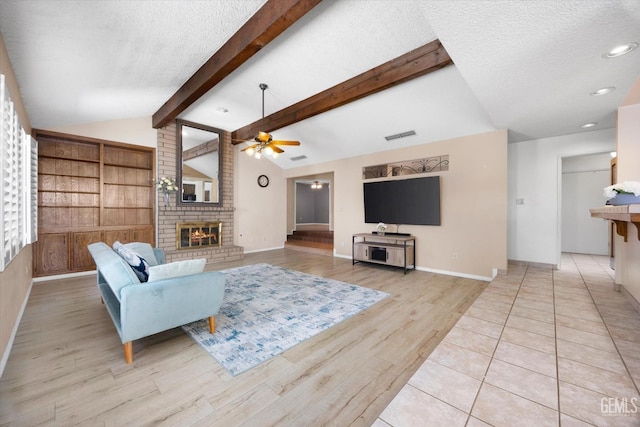 9408 Wandering Oak Dr, Bakersfield, CA 93311 - living area with a textured ceiling, ceiling fan, a fireplace, light wood finished floors, and baseboards