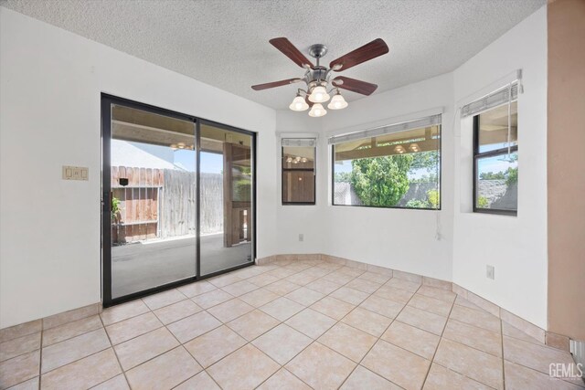 9408 Wandering Oak Dr, Bakersfield, CA 93311 - spare room with a textured ceiling, plenty of natural light, a ceiling fan, and light tile patterned floors