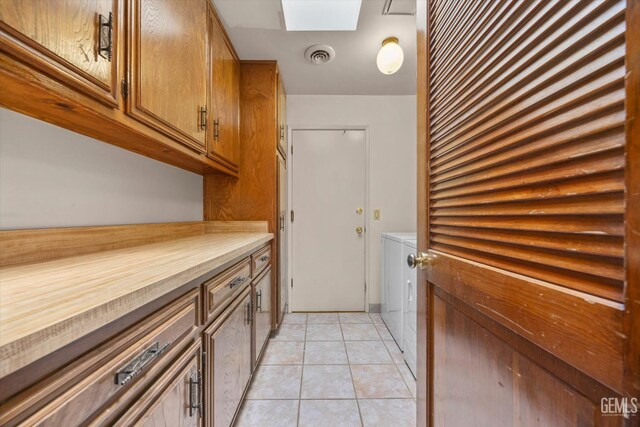 9408 Wandering Oak Dr, Bakersfield, CA 93311 - laundry room with independent washer and dryer, light tile patterned floors, and a skylight
