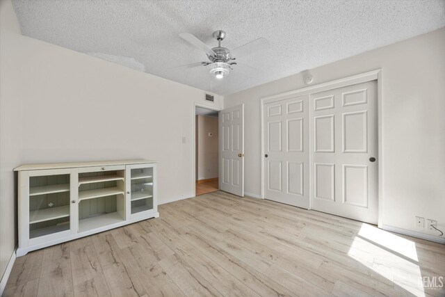 9408 Wandering Oak Dr, Bakersfield, CA 93311 - unfurnished bedroom with wood finished floors, a textured ceiling, a closet, a ceiling fan, and baseboards