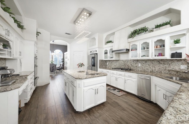 10505 Finchley Dr, Bakersfield, CA 93311 - kitchen with open shelves, arched walkways, a sink, a chandelier, and appliances with stainless steel finishes