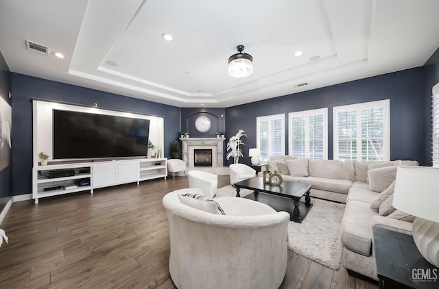 10505 Finchley Dr, Bakersfield, CA 93311 - living area featuring a tray ceiling, dark wood-type flooring, a fireplace, recessed lighting, and baseboards