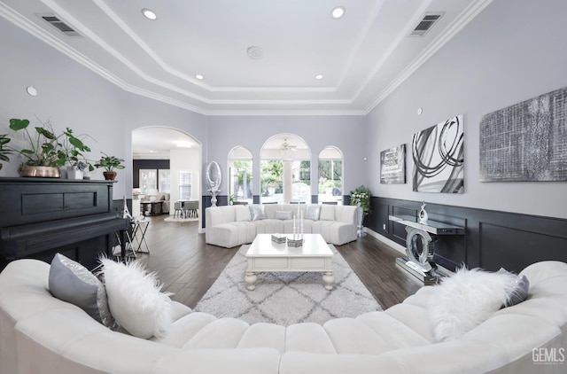 10505 Finchley Dr, Bakersfield, CA 93311 - living area featuring a tray ceiling, arched walkways, dark wood-style flooring, and crown molding