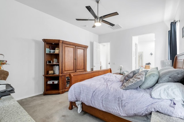 bedroom with a ceiling fan, visible vents, light carpet, baseboards, and ensuite bathroom