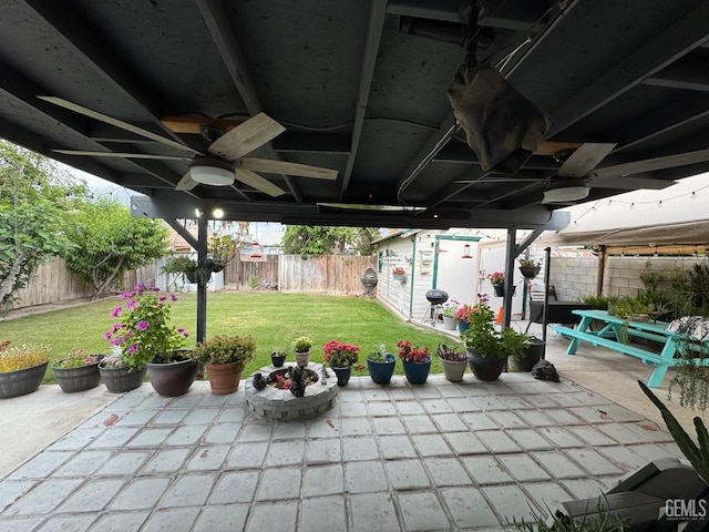 view of patio / terrace with ceiling fan, a fenced backyard, and an outbuilding