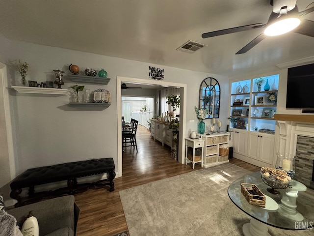 living area featuring visible vents, wood finished floors, and a ceiling fan