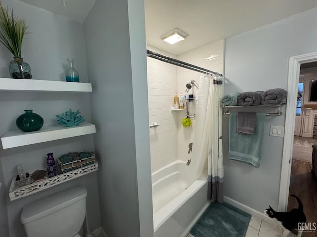 bathroom with baseboards, shower / bath combination with curtain, and toilet