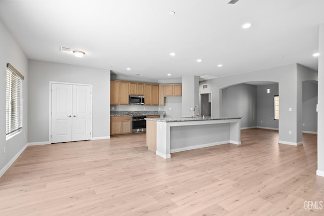 6522 Bangor Pl, Bakersfield, CA 93313 - kitchen with stove, arched walkways, stainless steel microwave, light wood-type flooring, and recessed lighting