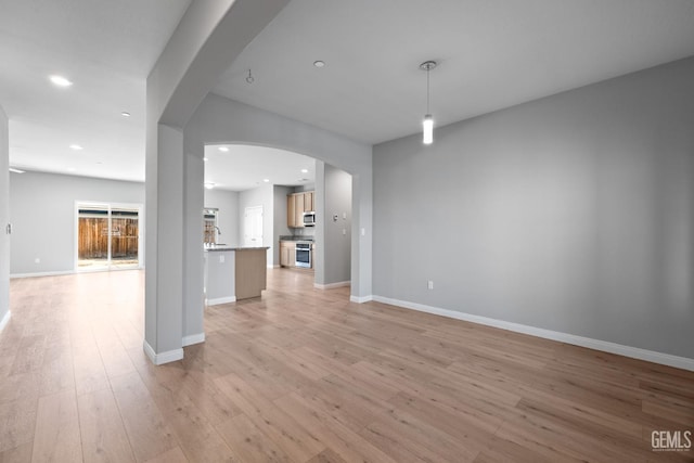 6522 Bangor Pl, Bakersfield, CA 93313 - unfurnished living room with arched walkways, light wood-style flooring, and recessed lighting