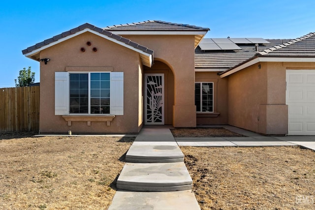 6522 Bangor Pl, Bakersfield, CA 93313 - view of front of property with stucco siding, solar panels, a tile roof, and an attached garage