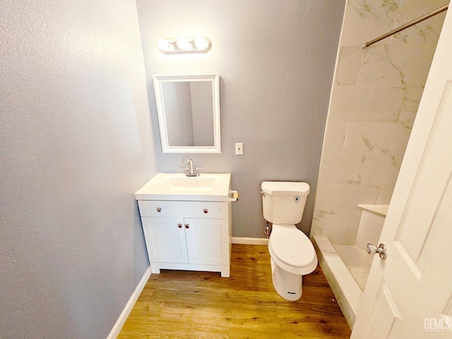 bathroom with vanity, toilet, wood-type flooring, and a shower