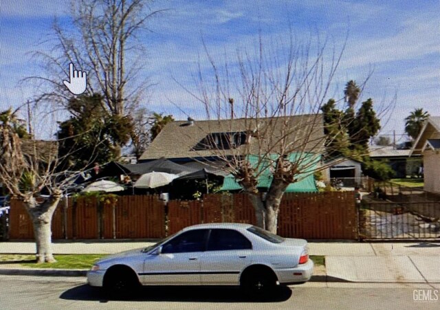 706 L St, Bakersfield, CA 93304 - view of side of home with fence, stucco siding, and a patio area