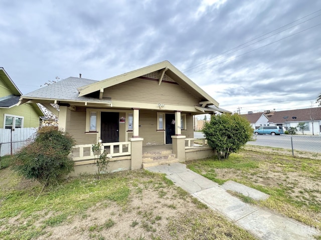 bungalow with a porch and fence