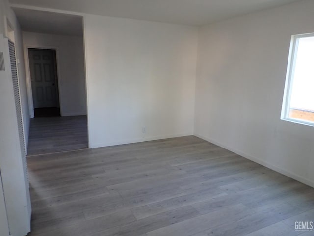 unfurnished room featuring baseboards and wood finished floors