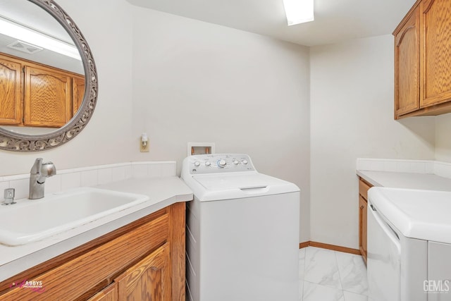 laundry room with washing machine and clothes dryer, baseboards, cabinet space, marble finish floor, and a sink