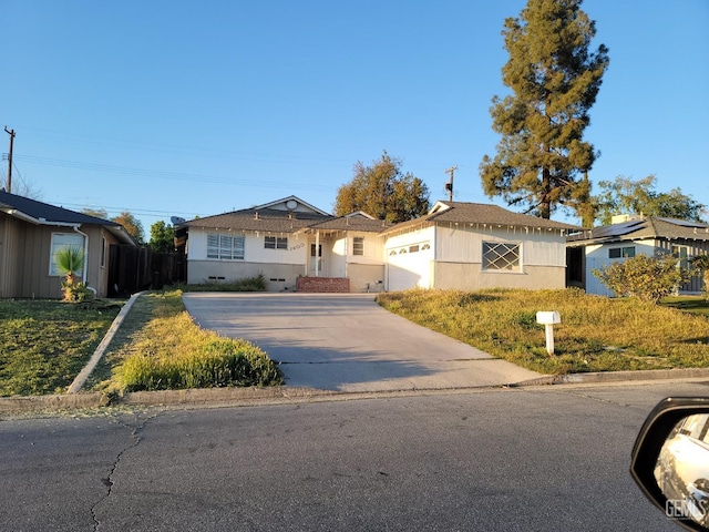 single story home with concrete driveway, fence, and a garage