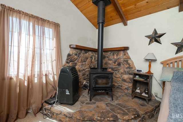 interior details featuring beam ceiling, wooden ceiling, and a wood stove