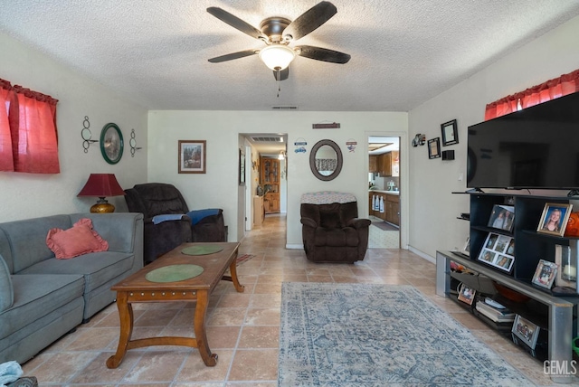 living room with ceiling fan and a textured ceiling