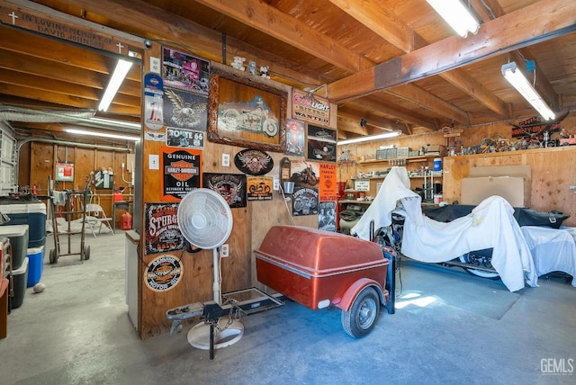 garage featuring a workshop area and wood walls