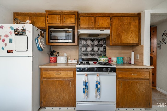 kitchen featuring tasteful backsplash and white appliances