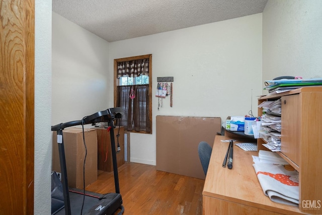 office space with a textured ceiling and light hardwood / wood-style flooring