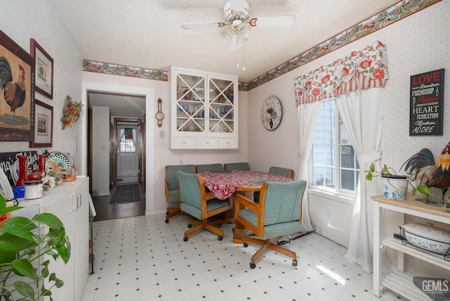 dining area featuring ceiling fan and a textured ceiling