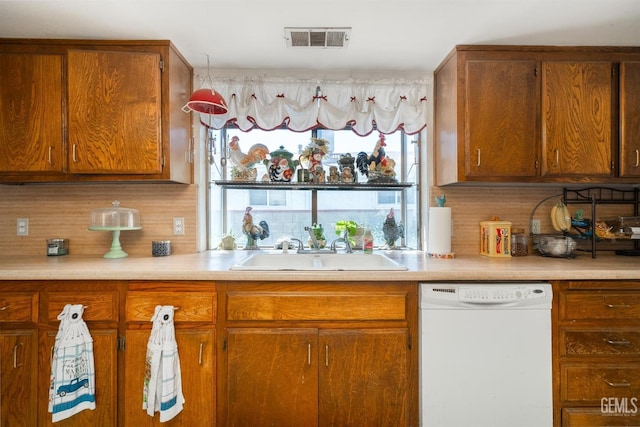 kitchen featuring tasteful backsplash, sink, and white dishwasher