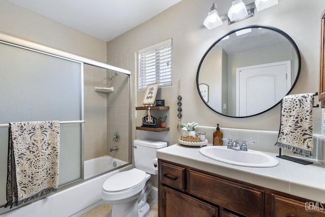 full bathroom featuring enclosed tub / shower combo, vanity, and toilet