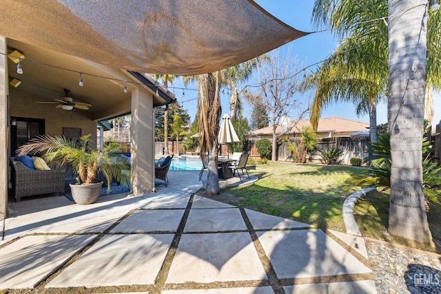 view of patio / terrace with ceiling fan and a fenced in pool